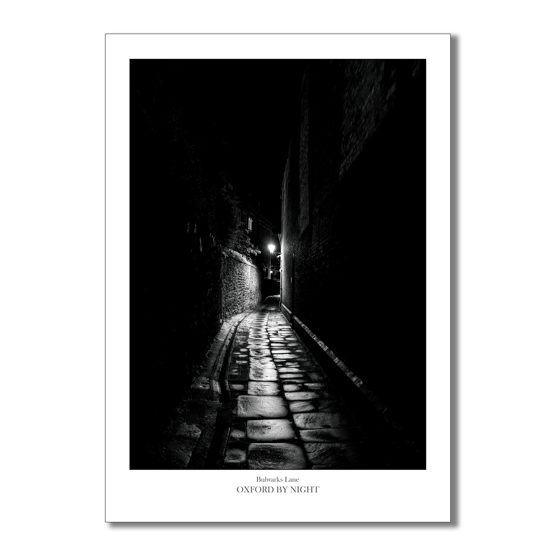 Relive the enchantment of your Oxford visit with this evocative and eerie black and white photographic art print of the narrow cobbles of Bulwarks lane. 